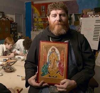 Photo of Fr. Daniel holding an Icon he painted.